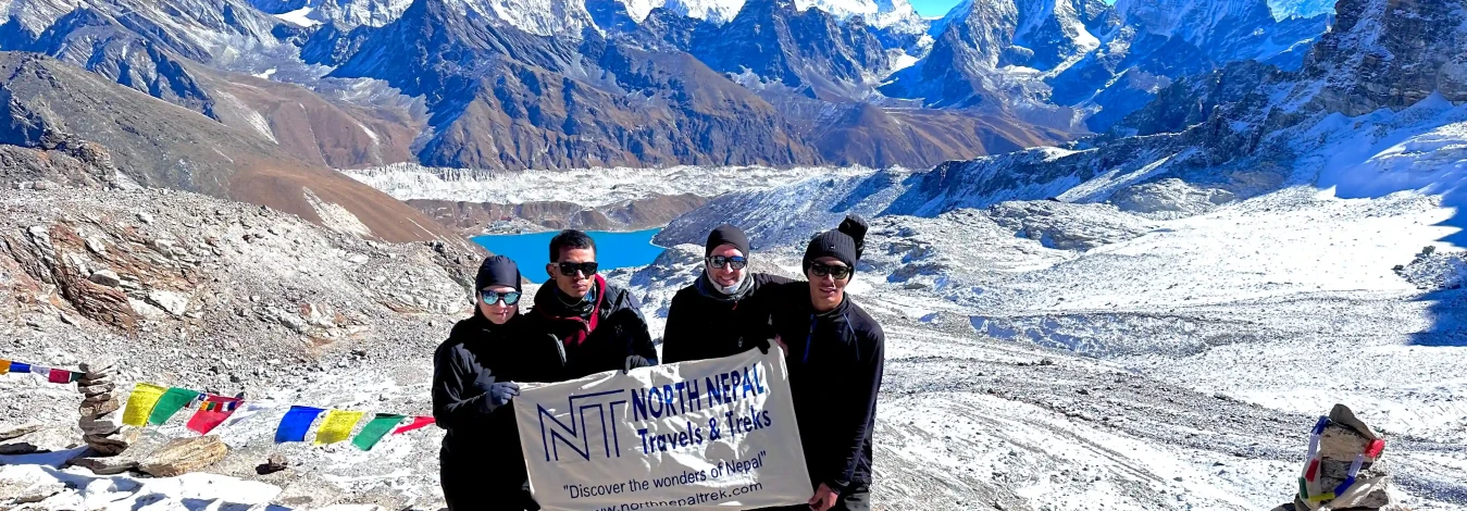 Trekkers from North Nepal Trek clicking photo holding north nepal banner in Kangla Pass during Three Passes Trek.
